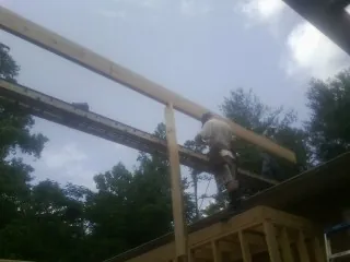 Carpenter setting a ridge beam over a new addition frame — Ice Dam Removal by Roofing Brothers in Congerville